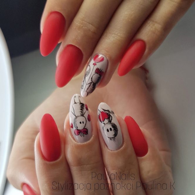 Nails painted matte red with two white accent nails featuring cute panda drawings wearing red bows and scarves on a manicure.