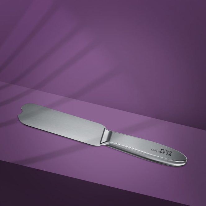 Stainless steel cake knife with a wide blade and rounded tip on a purple background.
