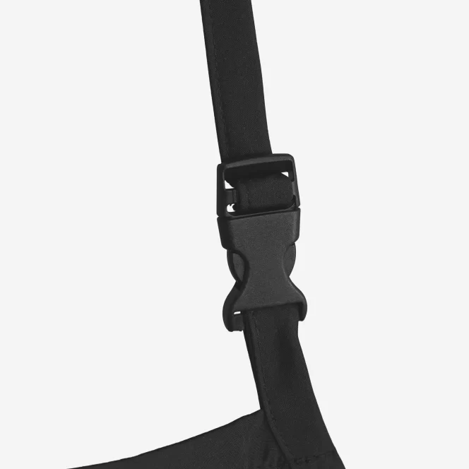 Close-up of a black plastic quick-release buckle on an adjustable strap of a bag or backpack.