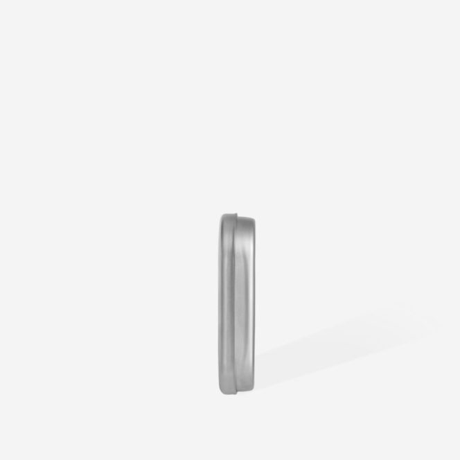 Silver-toned ring standing upright on a white backdrop, with a soft shadow to the right.