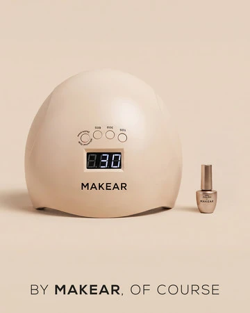 Beige MAKEAR nail curing lamp with a digital timer display, shown beside a small Makear nail polish bottle.